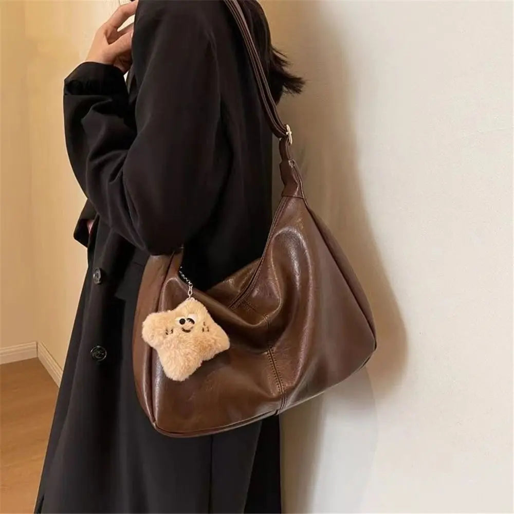 Bolso hobo Lena en marrón llevado al hombro