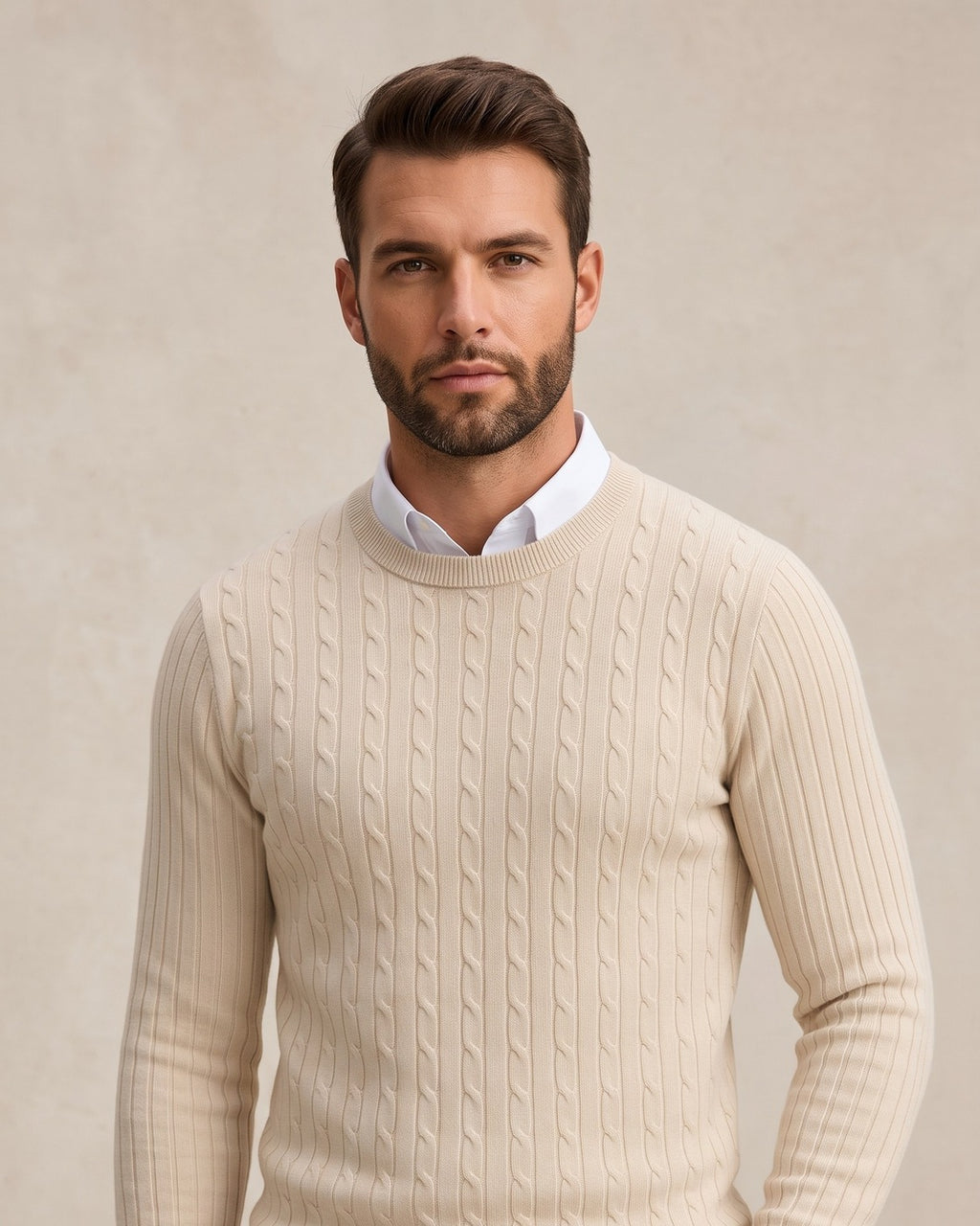 Hombre con jersey de punto trenzado crudo sobre camisa blanca