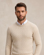 Hombre con jersey de punto trenzado crudo sobre camisa blanca