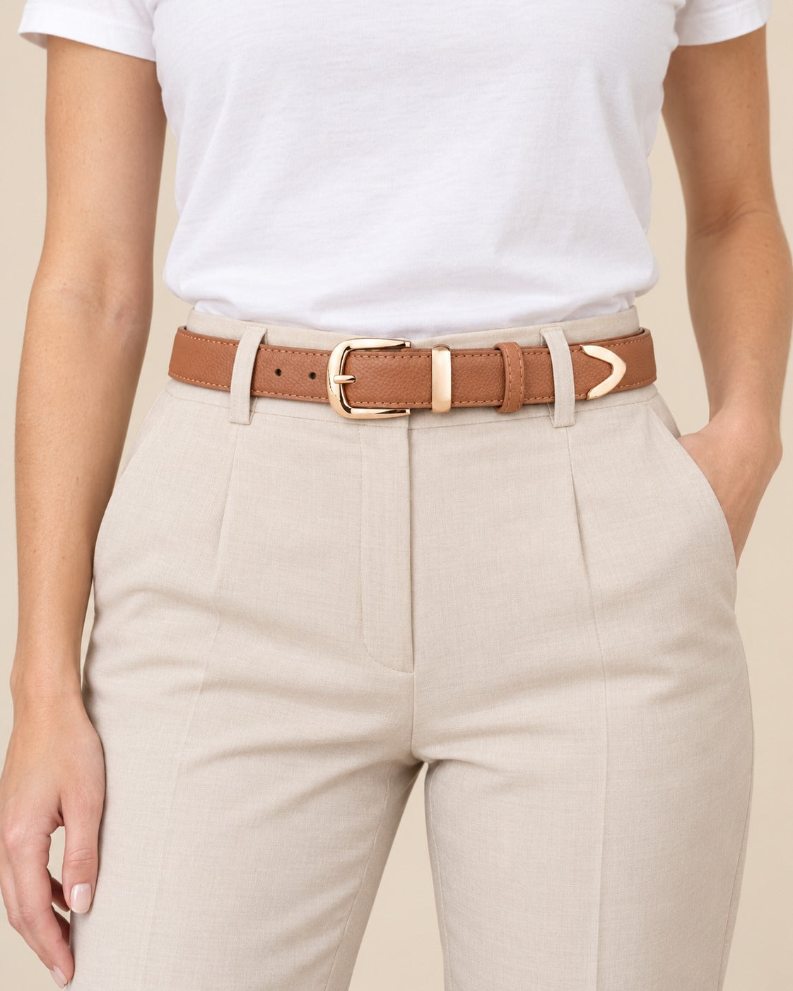 Modelo con el cinturón de hebilla dorada Nora en color camel sobre pantalón beige